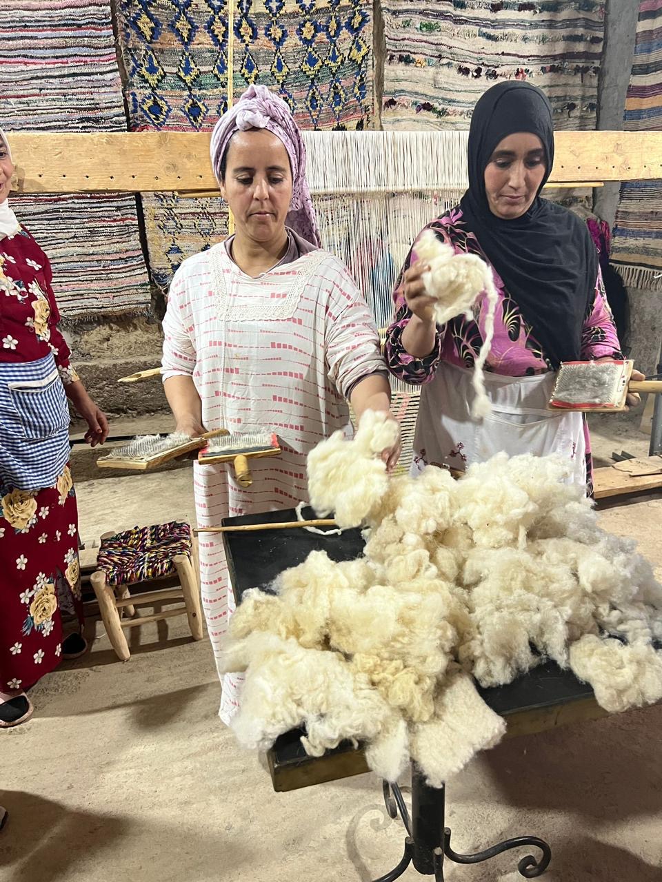 Artisans carding raw wool in the workshop