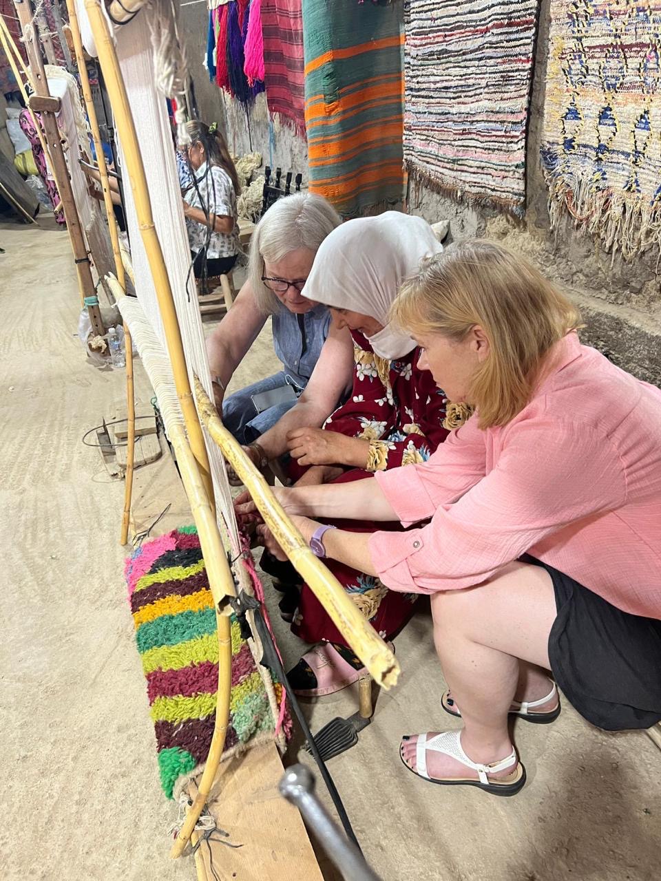 Guests learning to tie knots at the loom